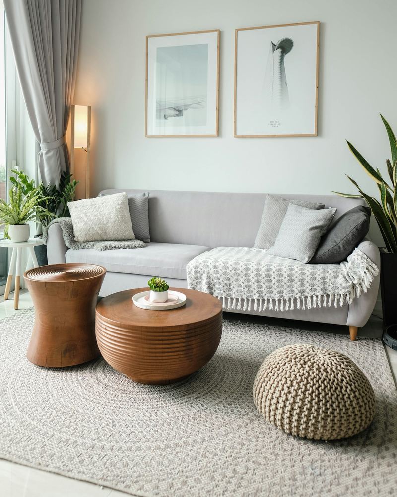 Ljust vardagsrum med soffa, pallar och växter
