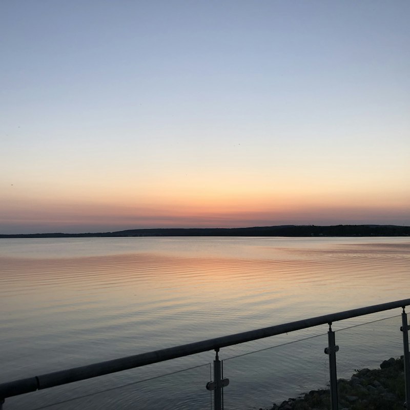 Kvällsljus över sjön, sett från strandpromenaden i Motala